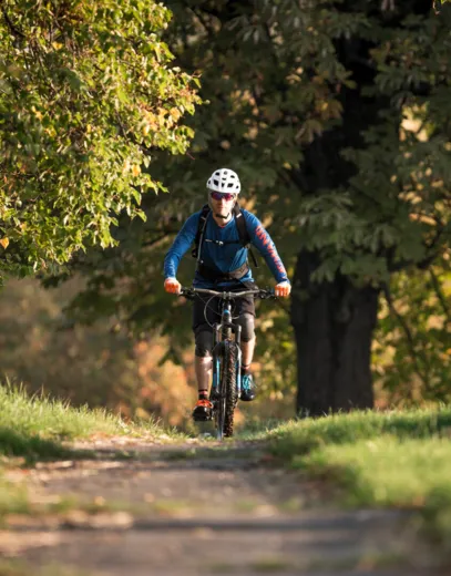 Eine Radfahrerin fährt einen Feldweg entlang